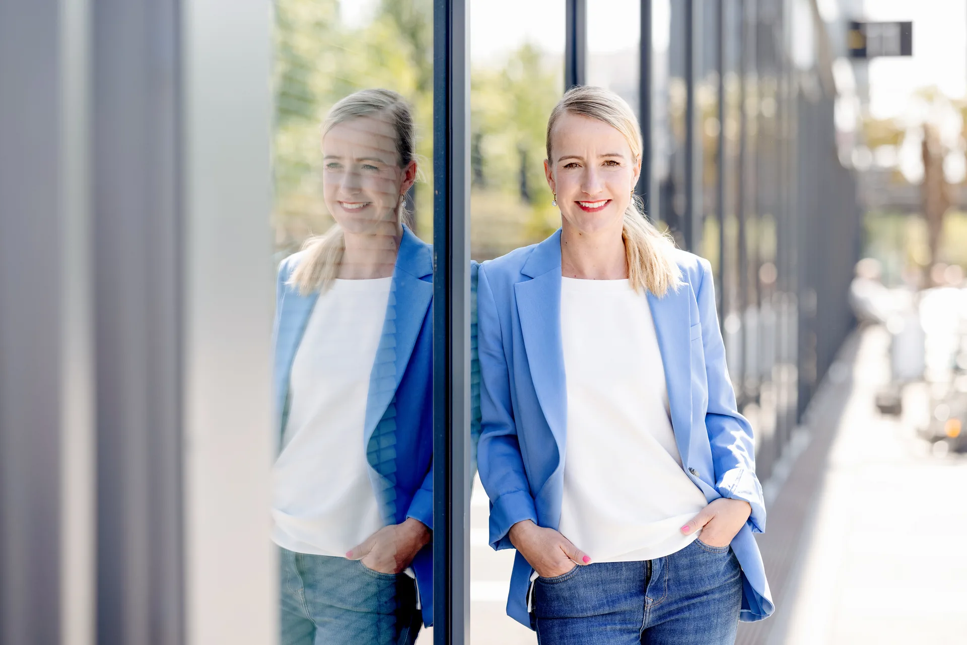 Tanja Petersen an einer Glasfassade mit Spiegelung