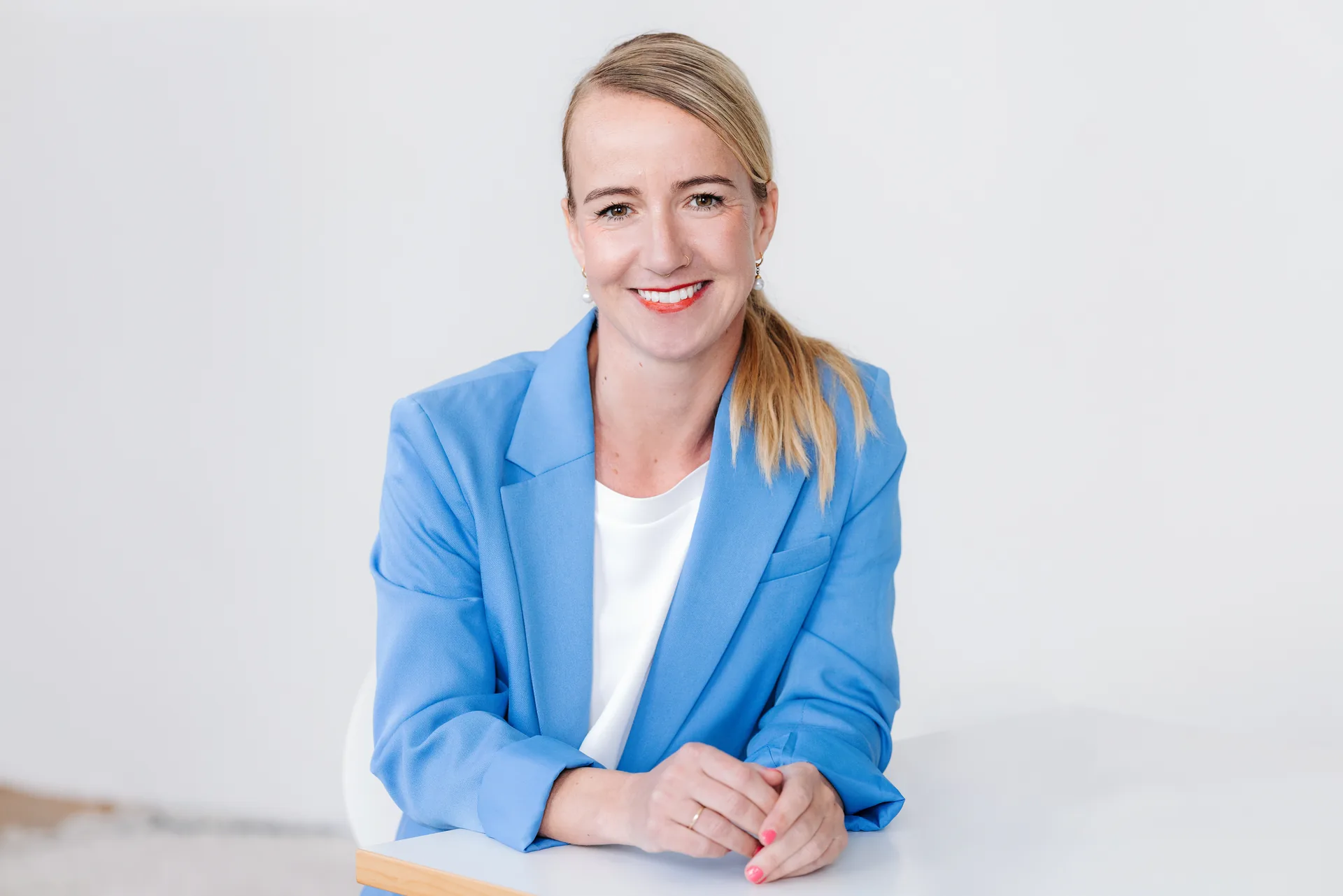 Tanja Petersen im blauen Blazer an einem Tisch